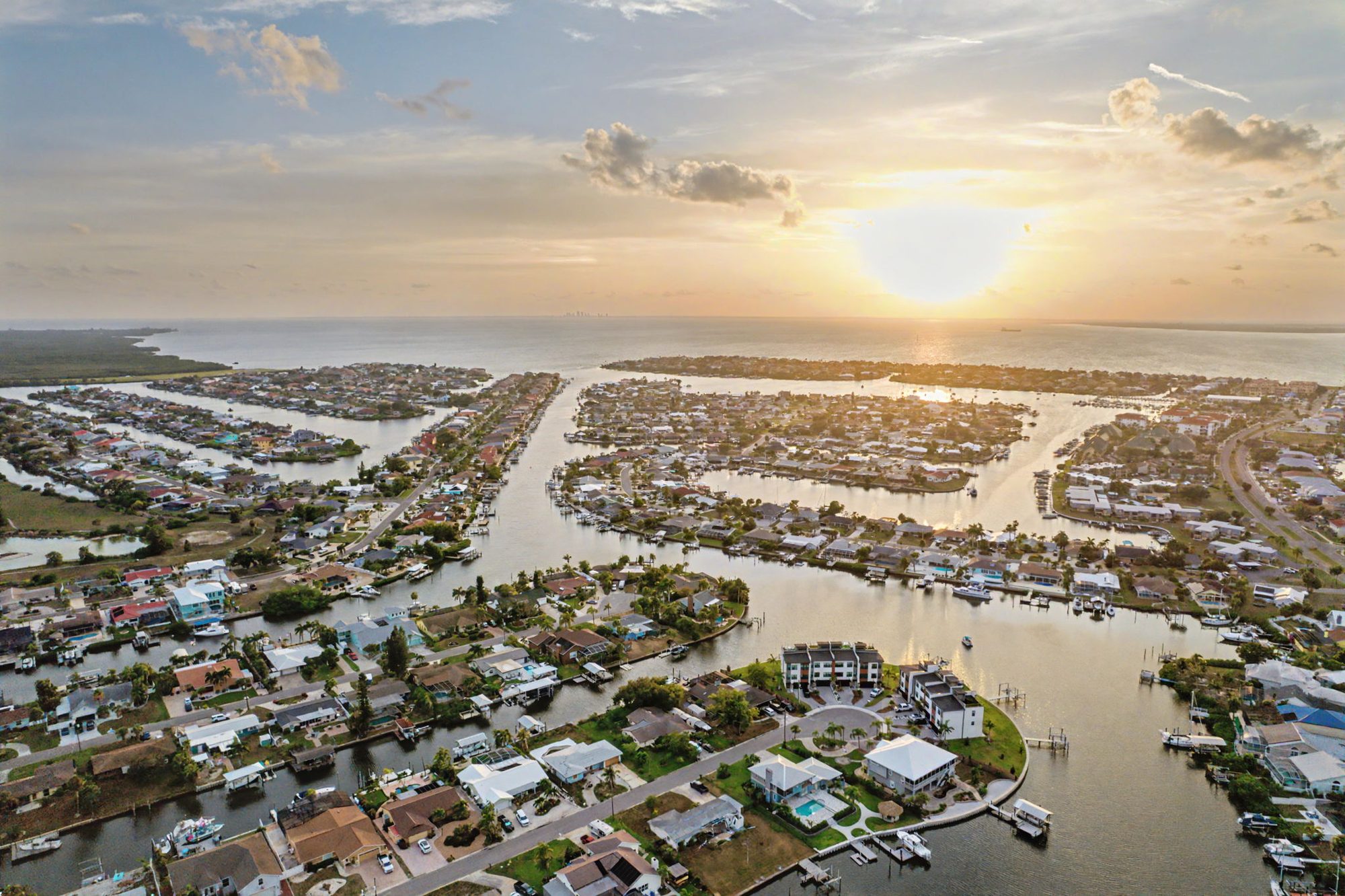 Aerial drone photo of a waterfront neighborhood at sunset