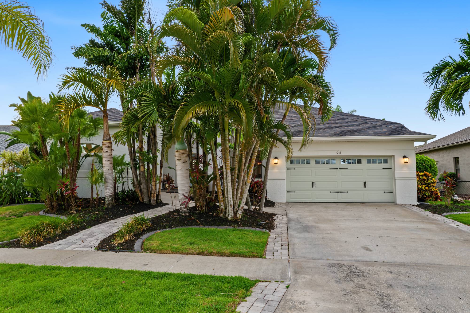 Front of a Florida home with palms and a two-car garage